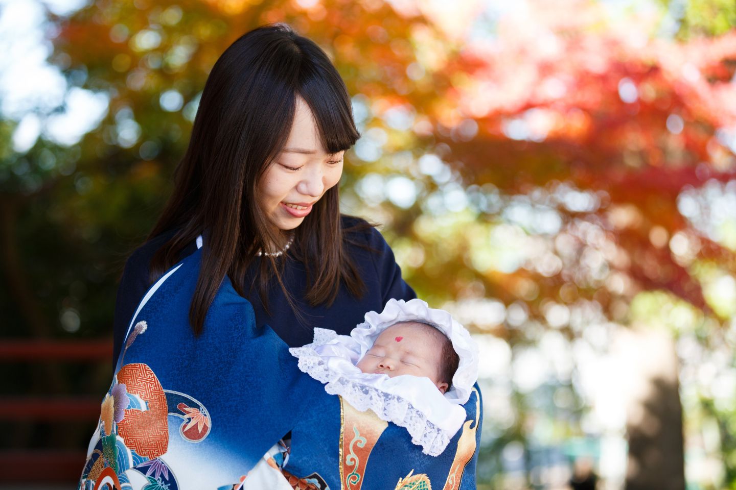 紅葉を背景にママとお宮参りツーショット