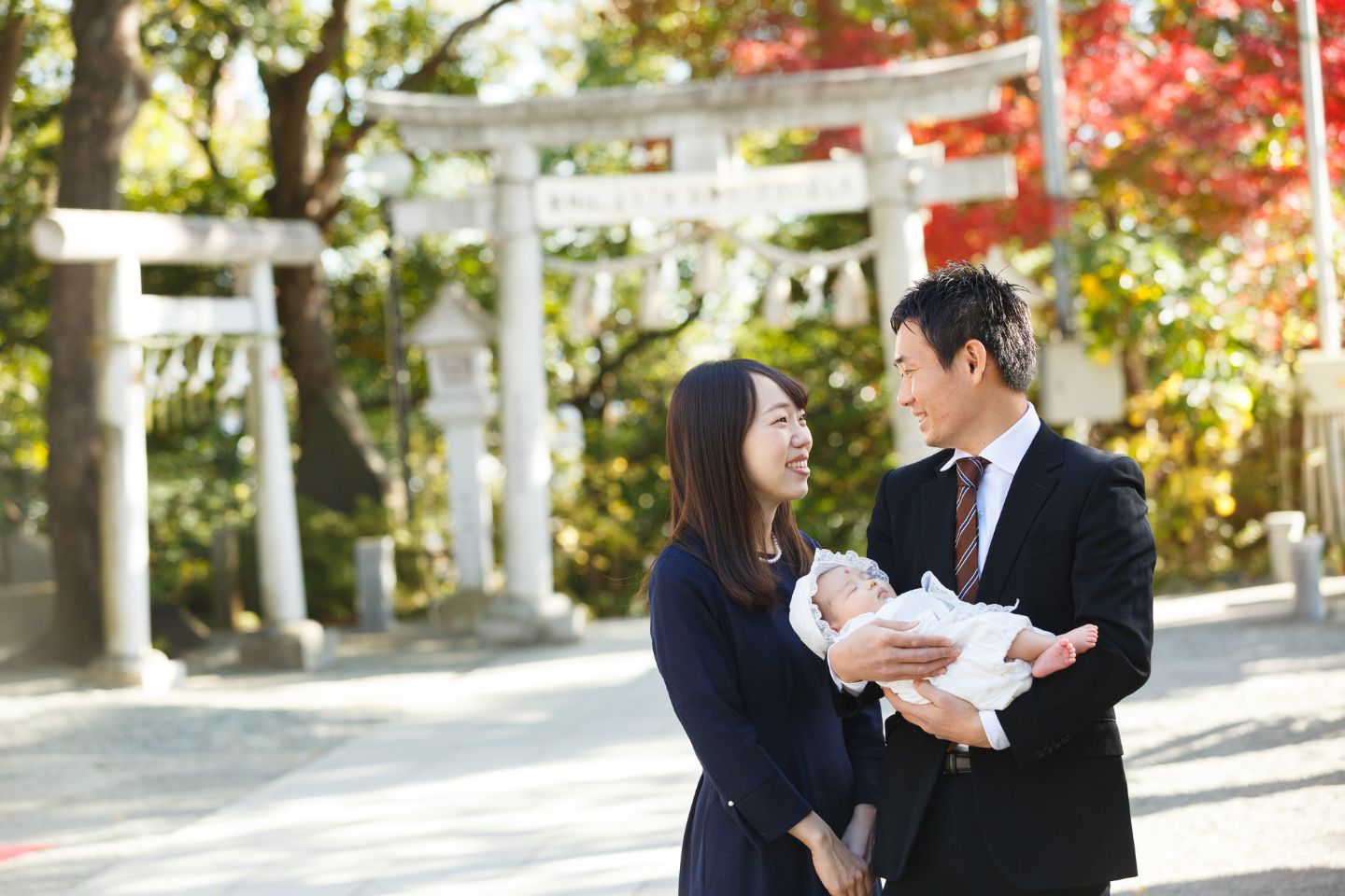 お宮参りで見つめ合うパパとママ