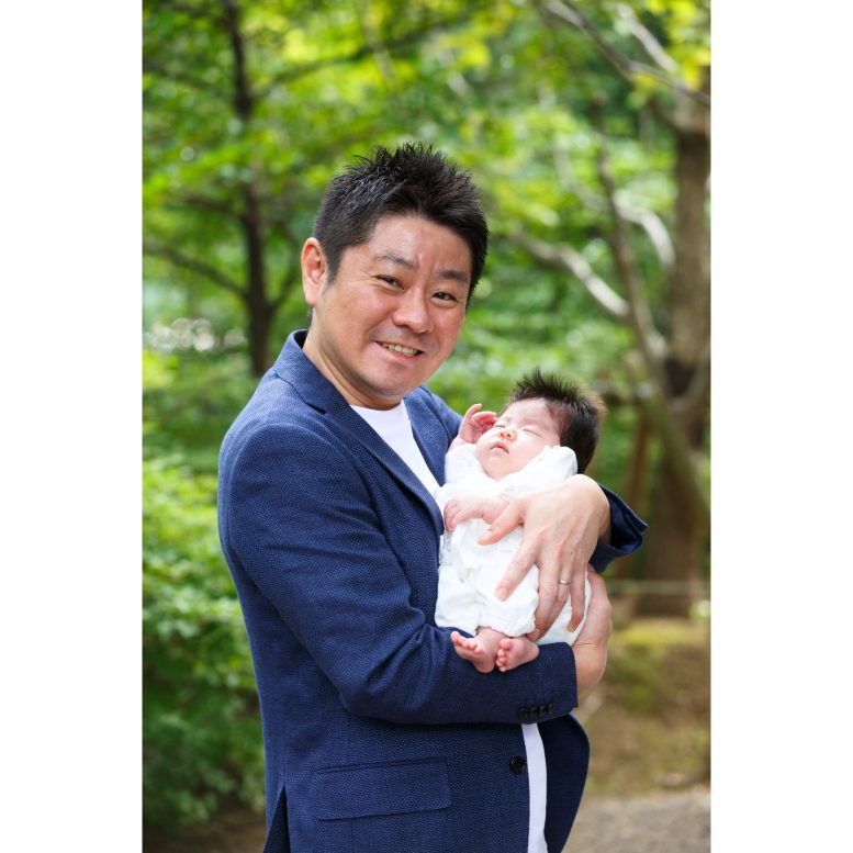 ベビードレスの赤ちゃんを抱っこするパパ